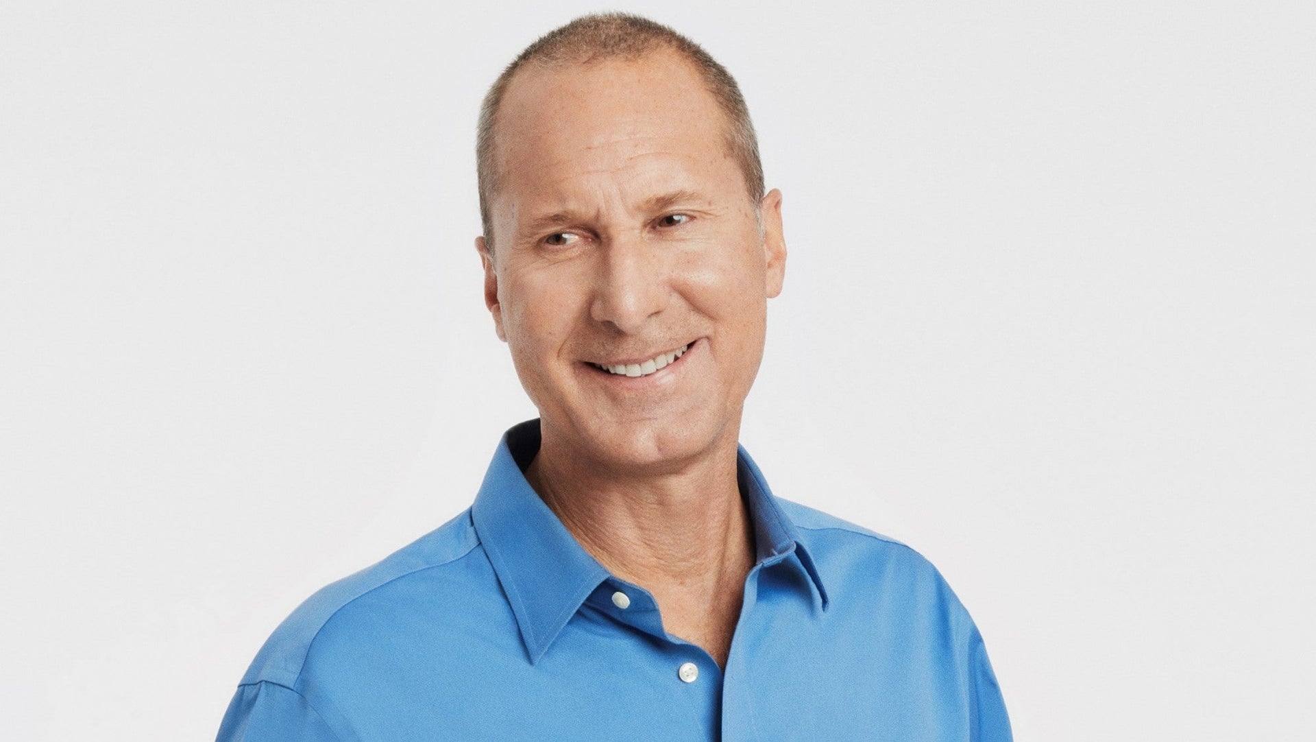 Portrait of a smiling man in a blue shirt.