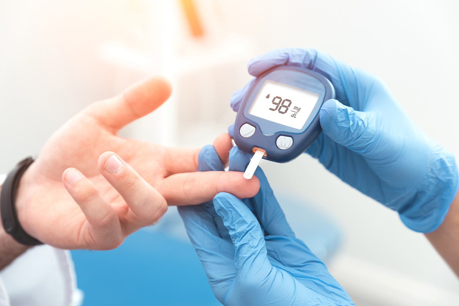 Gloved hands checking blood sugar with a glucose meter.