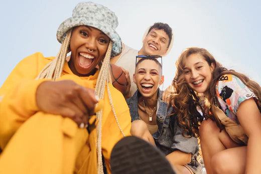 Group of friends smiling and laughing outdoors.