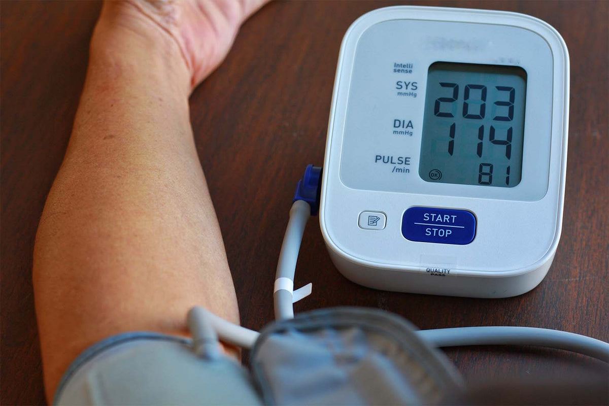 Digital blood pressure monitor displaying high reading.