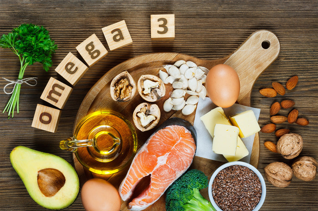 Foods rich in Omega-3, including salmon, nuts, and oil, on a wooden board.