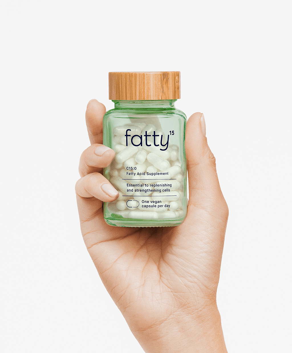 Hand holding Fatty15's C15 supplement bottle with capsules.