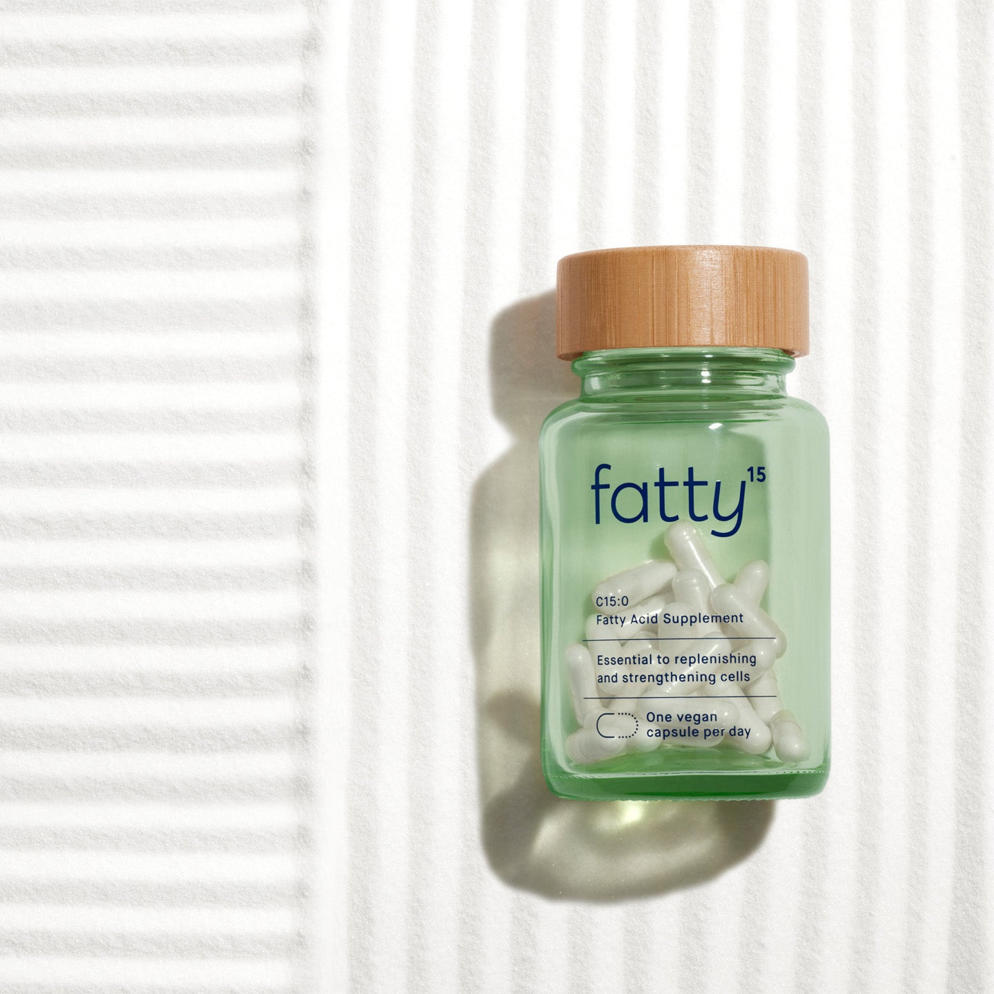 Fatty15's C15 supplement bottle on striped background.
