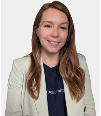 Smiling woman in a light blazer against a neutral background.