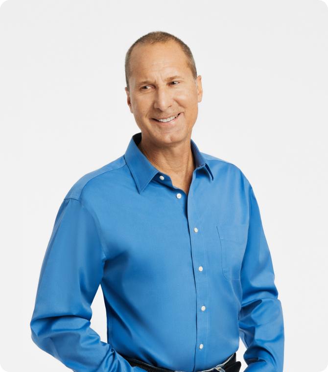 Man in a blue shirt smiling confidently.