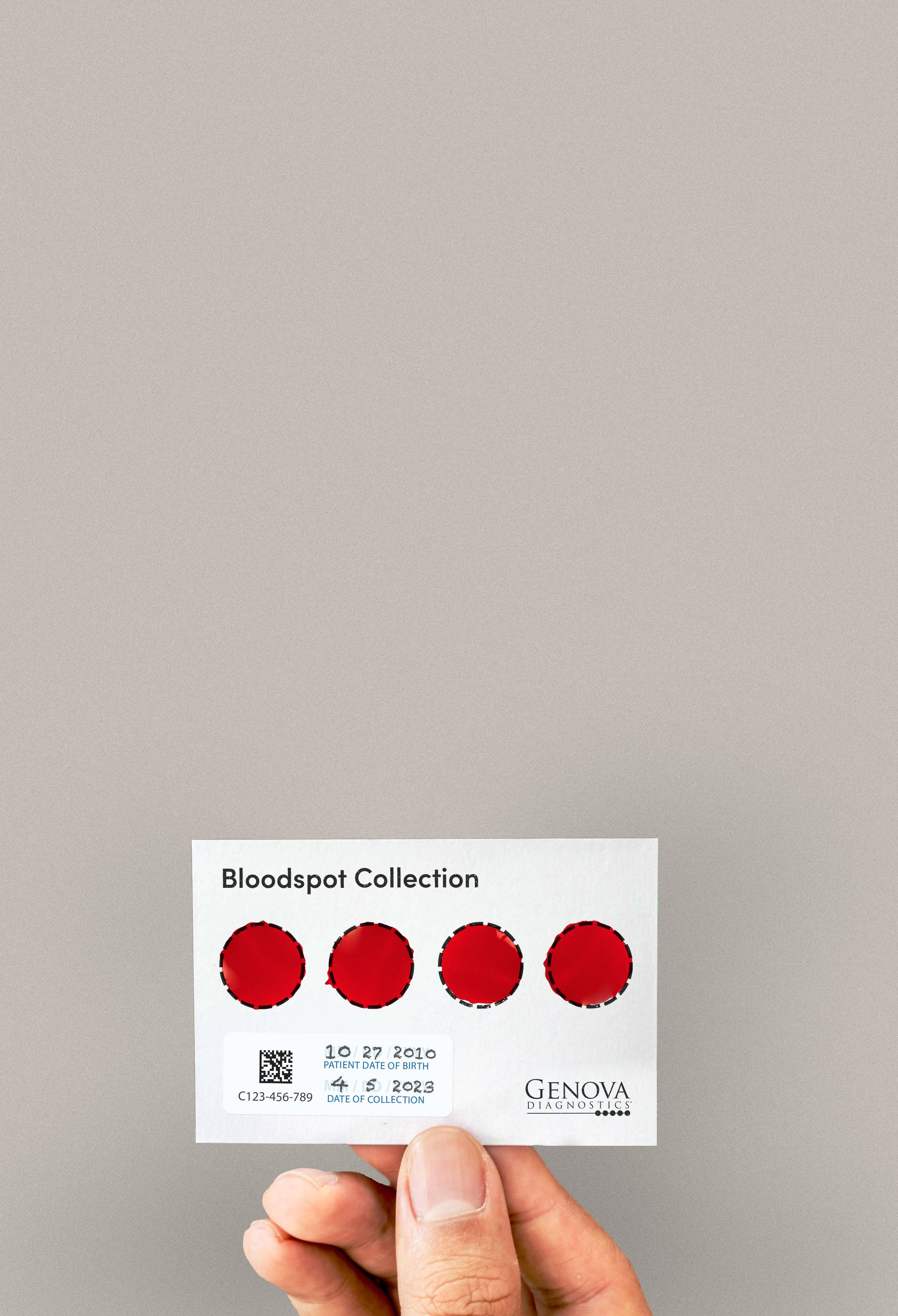 Hand holding blood sample card with red circular spots on a neutral background.