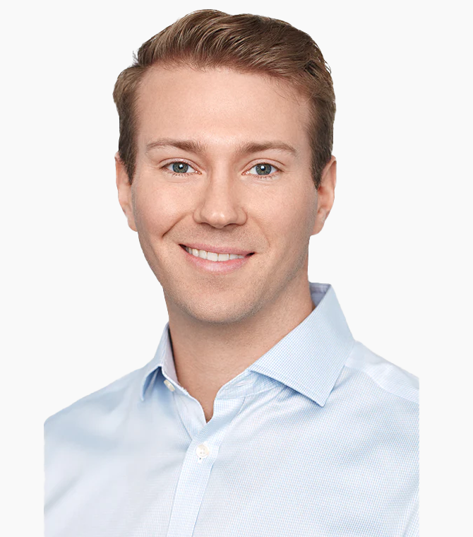 Smiling person in a light blue shirt on a white background.