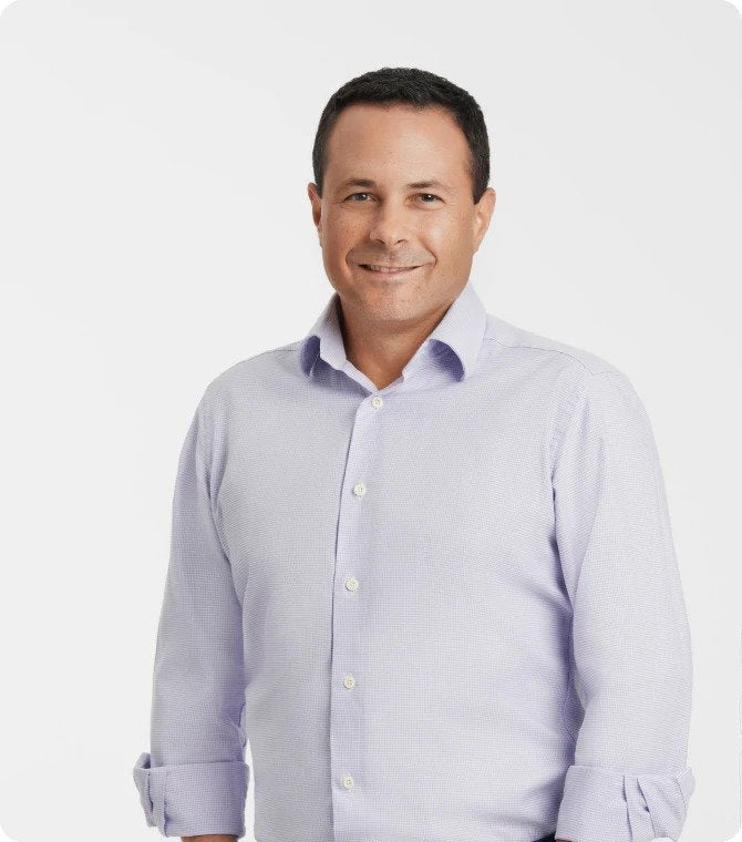 A person in a light shirt smiling at the camera.