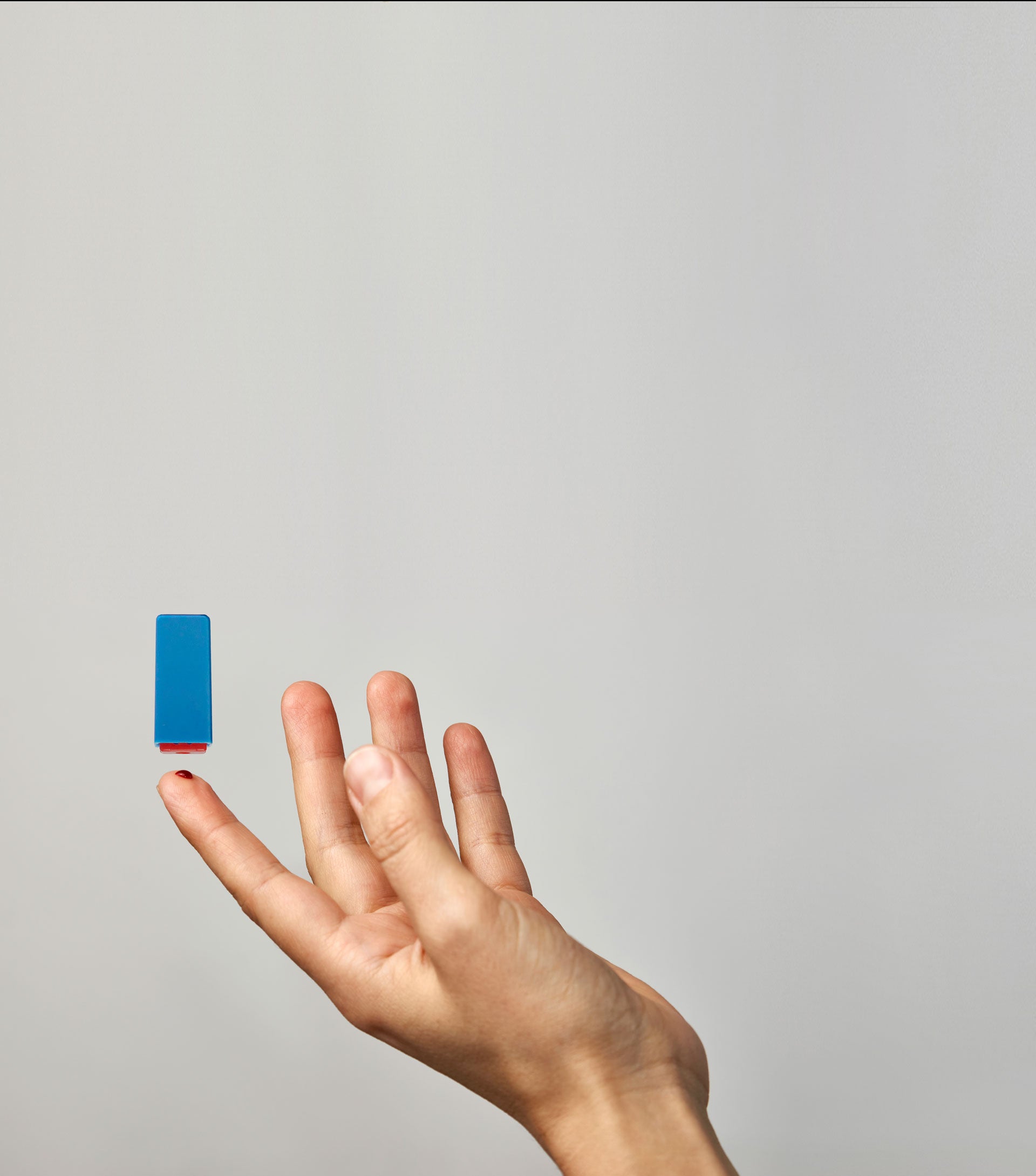 Hand holding a blue fatty15 C15 supplement against a neutral background.