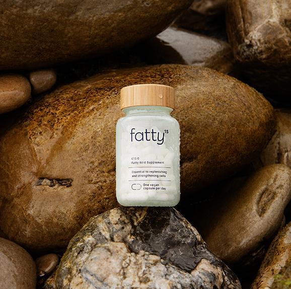 Fatty15's C15 supplement bottle on natural rocks background.