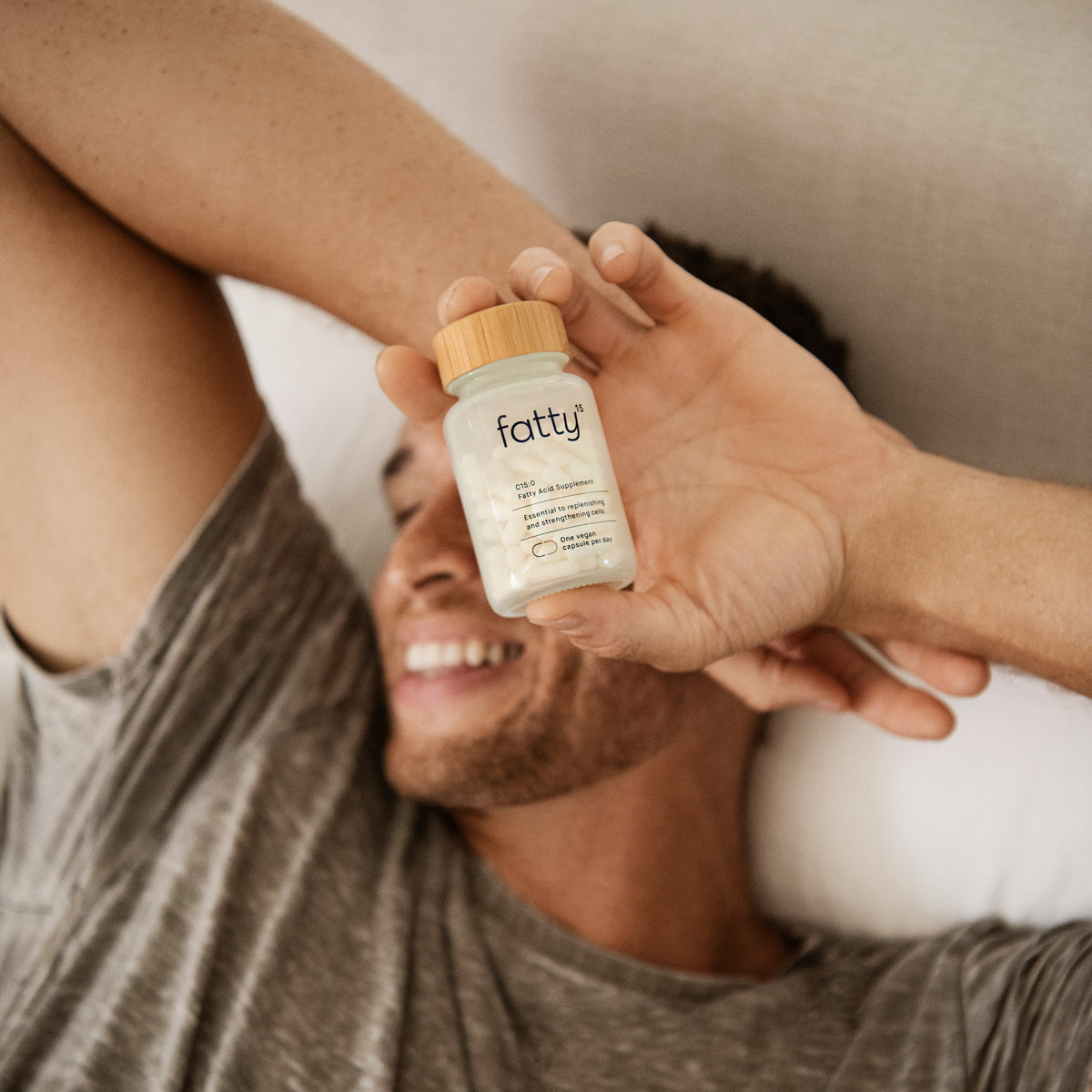 Man holding Fatty15 bottle, C15 supplement in hand.